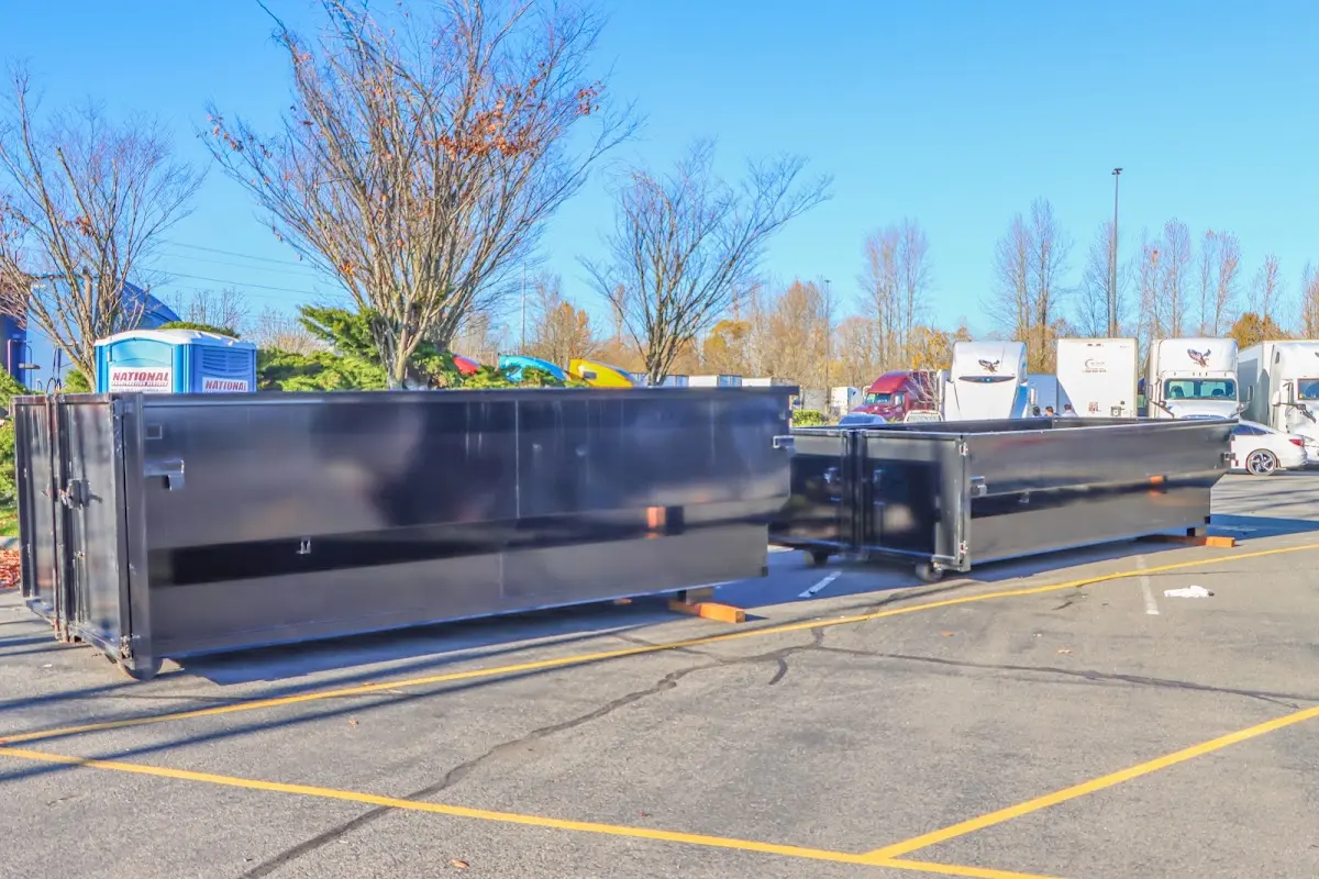 Professional dumpster rental service with roll-off container on residential driveway in Mandan